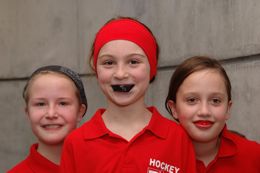 3 junge, sicherheitsbewusste Nachwuchssportlerinnen, die stolz (und etwas albern) ihren Sport-Mundschutz präsentieren