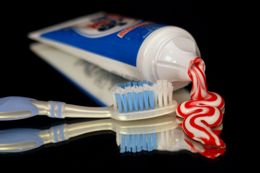 Zahnpastatube, aus der Zahnpasta herausgedrückt ist, und Zahnbürste